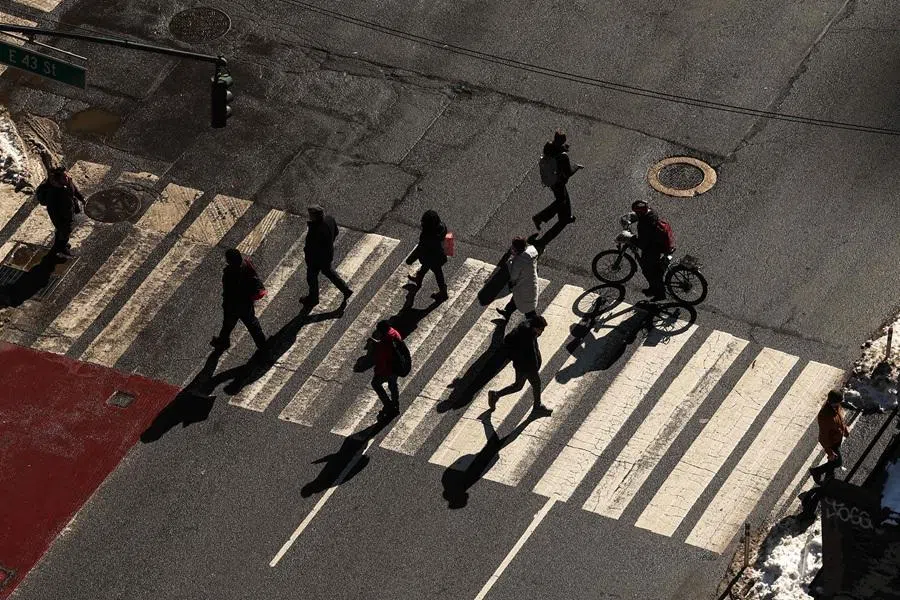 People walk across Third Avenue in the Manhattan borough of New York City on 25 February 2026.