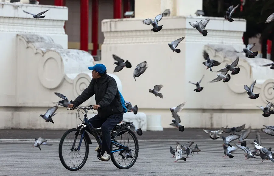 A man rides a bicycle past the entrance of Chiang Kai-shek Memorial Hall in Taipei on 29 November 2024. (I-Hwa Cheng/AFP)