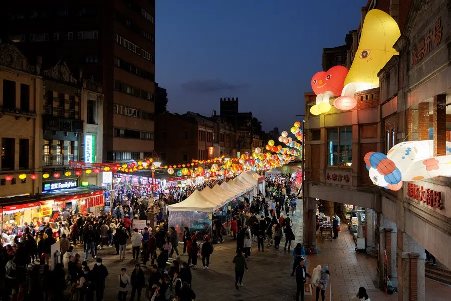 A street is filled with festive decorations and crowded with people shopping, in Taipei on 19 January 2025. (Cheng Yu-chen/AFP)
