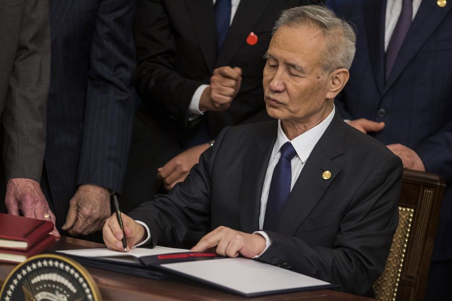 Liu He, China's vice premier, signs the US-China phase one trade agreement during a ceremony with US President Donald Trump in Washington on 15 January 2020. (Zach Gibson/Bloomberg)