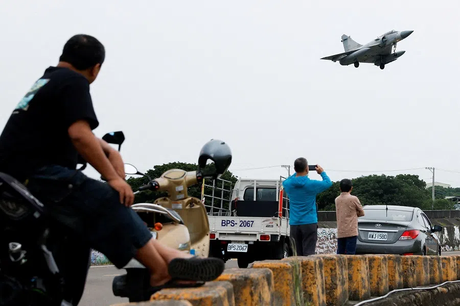 People look at a Taiwan Air Force Mirage 2000-5 aircraft as it prepares to land at Hsinchu Air Base in Hsinchu, Taiwan, on 23 May 2024.  (Carlos Garcia Rawlins/Reuters)