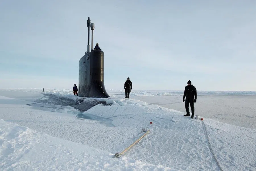 US Navy safety swimmers stand on the deck of the Virginia-class submarine USS New Hampshire after it surfaced through thin ice during exercises underneath ice in the Arctic Ocean north of Prudhoe Bay, Alaska, on 19 March 2011. (Lucas Jackson/Reuters)