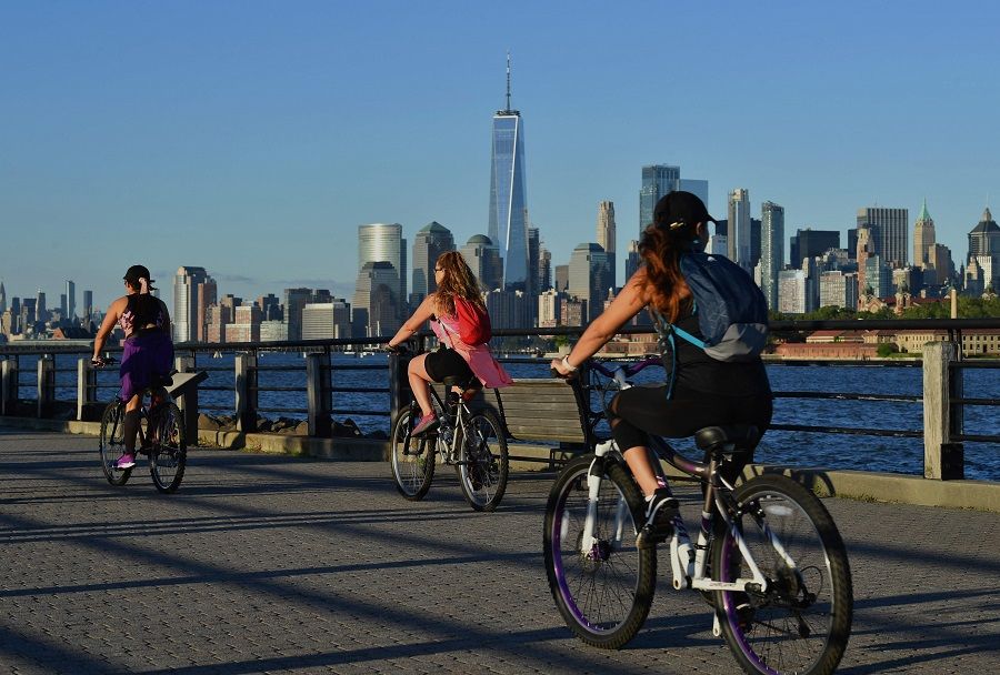 People ride their bikes along the waterfront at Liberty State Park on 24 June 2021 in Jersey City, New Jersey, US. (Angela Weiss/AFP)