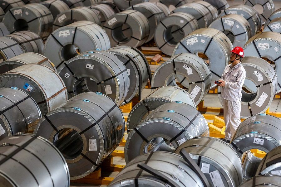 This file photo taken on 8 May 2021 shows a worker checking rolls of sheet aluminium at a factory in Wuhan, Hubei province, China. (STR/AFP)
