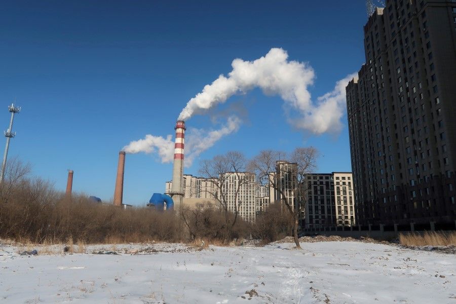 A coal-fired heating complex is seen behind the ground covered by snow in Harbin, Heilongjiang province, China, 15 November 2019. (Muyu Xu/Reuters)