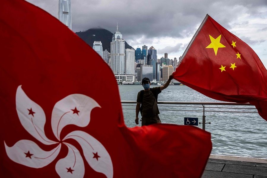 A man waves the Chinese flag to celebrate the 25th anniversary of the city's handover from Britain to China, in Hong Kong on 1 July 2022. (Isaac Lawrence/AFP)