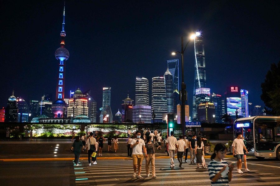 People walk on The Bund in the Huangpu district of Shanghai, China, on 12 July 2022. (Hector Retamal/AFP)