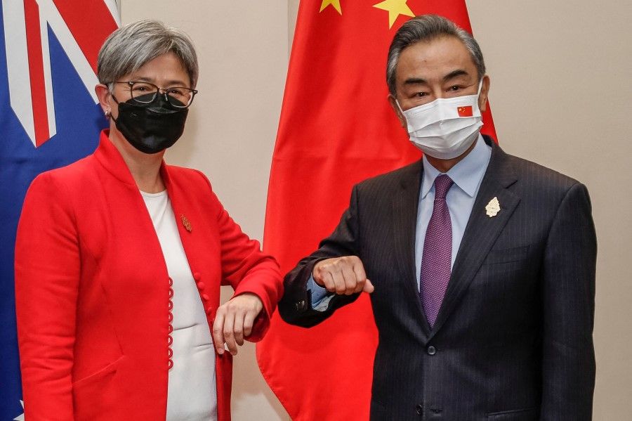 Australia's Foreign Minister Penny Wong (left) bumps elbows with China's Foreign Minister Wang Yi during their bilateral meeting on the sidelines of G20 Foreign Ministers Meeting in Nusa Dua on Indonesia's resort island of Bali on 8 July 2022. (Johannes P. Christo/AFP)