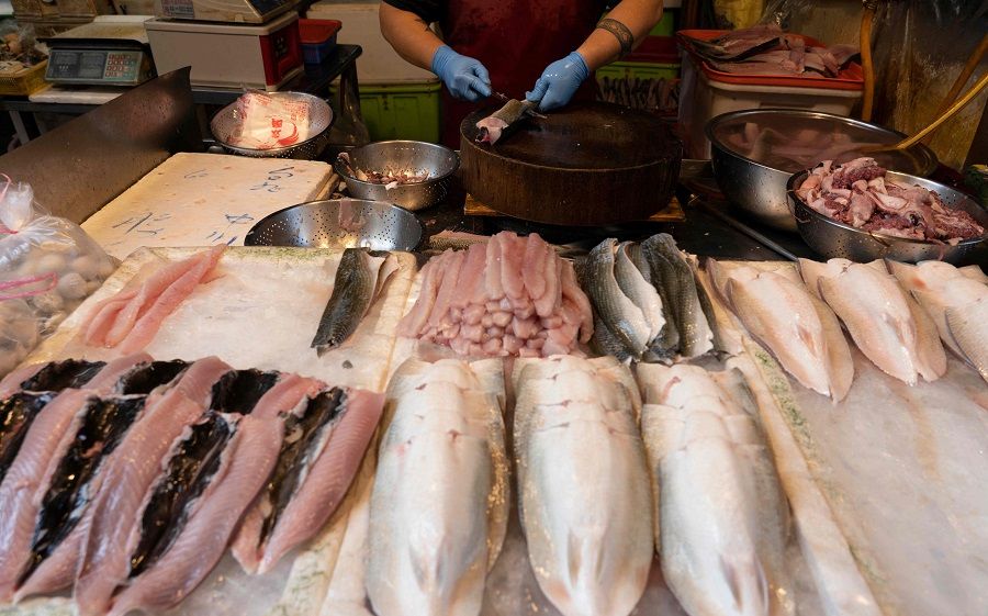 A milkfish vendor prepares fish at a market in Taipei, Taiwan, on 12 August 2022. (Asnaya Chou/AFP)