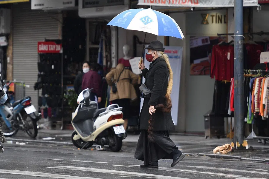 A woman walks on a street in Hanoi, Vietnam, on 17 January 2022. (Nhac Nguyen/AFP)