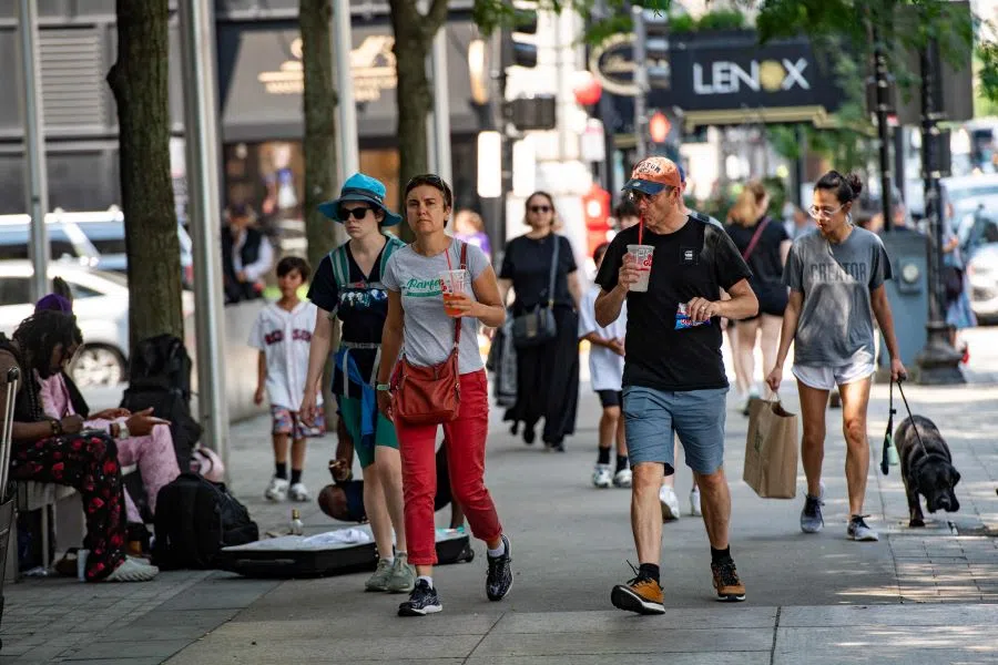 People carry from frozen drinks as they walk down Boylston Street during a heatwave in Boston, Massachusetts, on 19 June 2024. (Joseph Prezioso/AFP)