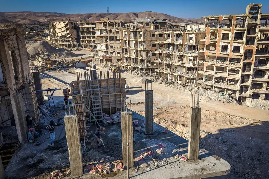 This aerial view shows construction workers at a construction site in Darayya on the outkirts of Damascus on 29 October 2025. (Dylan Collins/AFP)