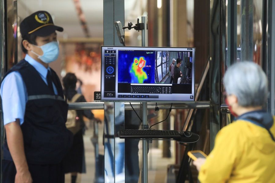A thermal camera detects the body temperature of a customer as a measure to prevent the spread of Covid-19 at an entrance of a restaurant in Taipei, Taiwan, 30 November 2021. (I-Hwa Cheng/Reuters)