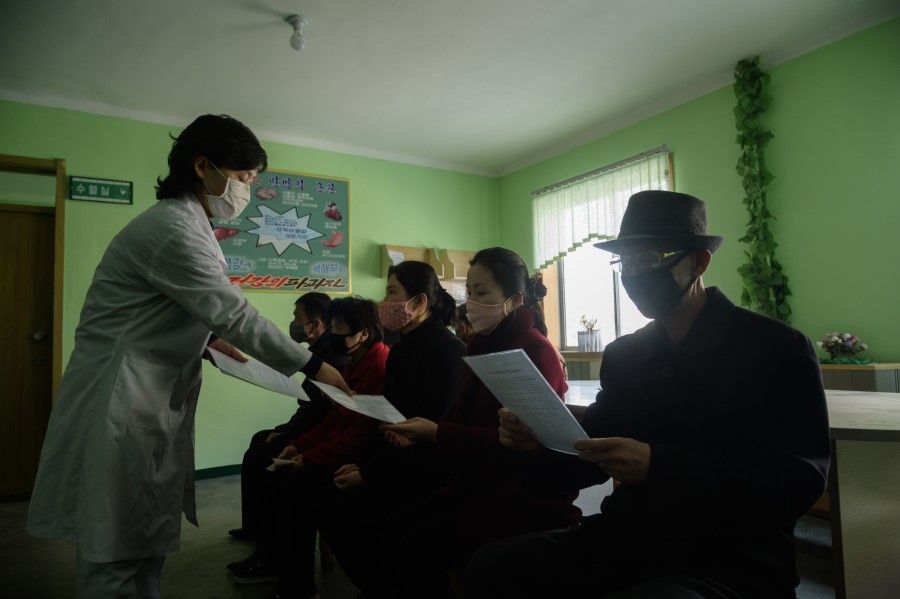 A doctor disseminates information about the Covid-19 coronavirus to people in a waiting room at the Pyongchon District People's Hospital in Pyongyang, 1 April 2020. (Kim Won Jin/AFP)