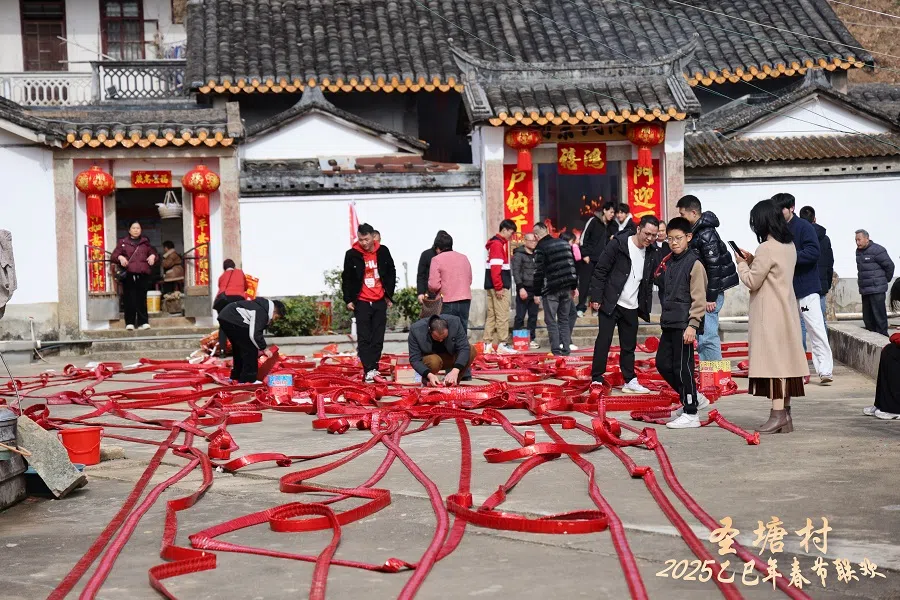 Singaporean relatives in awe of the firecrackers covering the ground of the ancestral hall.