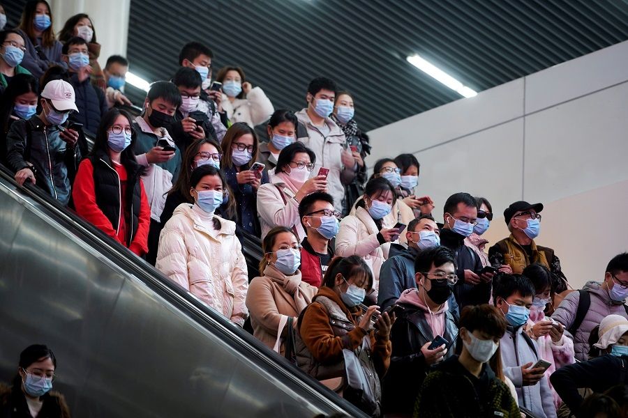 People wearing protective masks inside a subway station, 30 November 2021. Commuters are harried but still bother to help, says Jessie Tan. (Aly Song/Reuters)