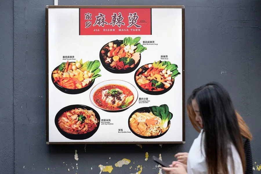People walking past a signboard of a mala stall in Chinatown, on 16 Sept 2024. (SPH Media)