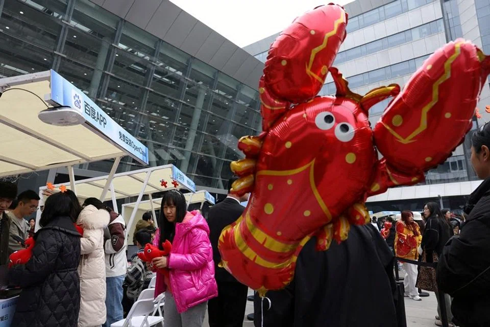 Participants line up near a lobster-shaped balloon to set up and install OpenClaw, an open-source AI agent, outside the Baidu offices in Beijing, China, on 17 March 2026. (Florence Lo/Reuters)