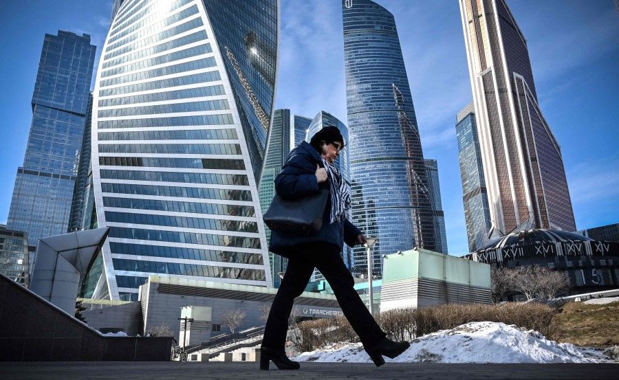 A woman walks in front of Moscow's International Business Centre (Moskva City) complex in Moscow on 11 March 2022. (AFP)