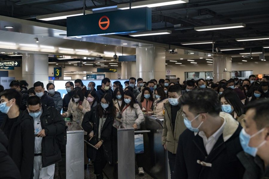 Evening commuters go through fare gates at a subway station in the Lujiazui financial district in Shanghai, China, 21 December 2020. (Qilai Shen/Bloomberg)
