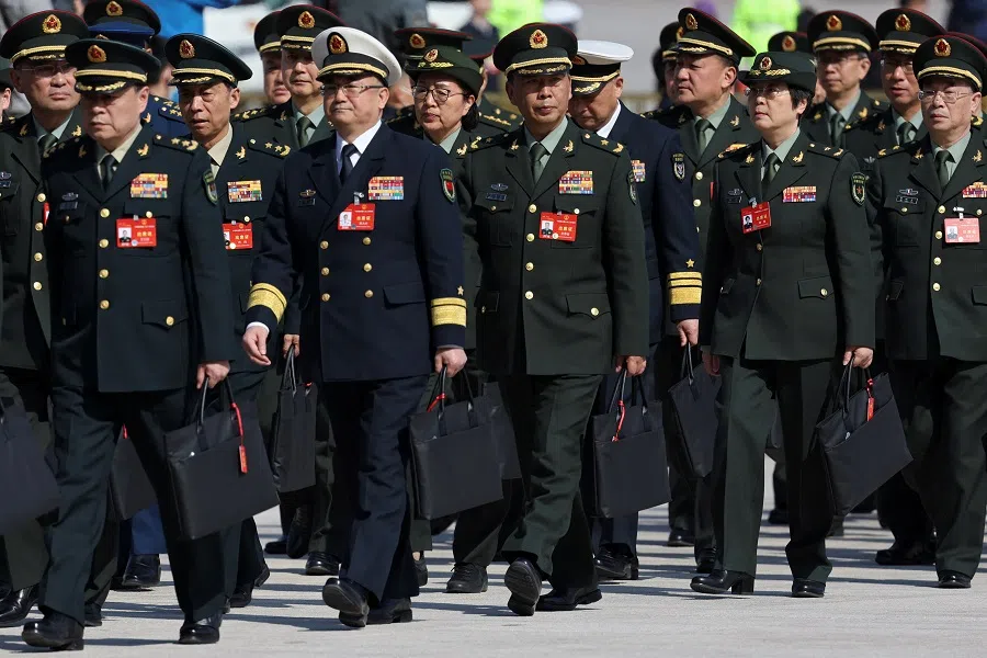 Members of the People’s Liberation Army (PLA) arrive for the closing session of the National People’s Congress (NPC), outside the Great Hall of the People in Beijing, China, on 11 March 2024. (Florence Lo/Reuters)