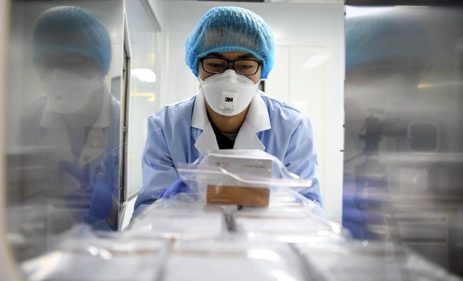 A picture released by Xinhua News Agency shows a researcher delivering the 2019-nCoV detection reagents at a company in Wuqing District, Tianjin, January 2020. (Xinhua)