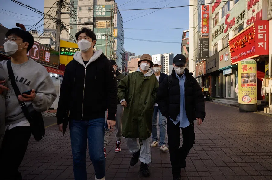 People walk along a street in Seoul, Korea, on 24 February 2021. (Ed Jones/AFP)