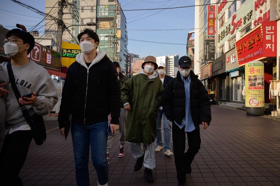 People walk along a street in Seoul, Korea, on 24 February 2021. (Ed Jones/AFP)