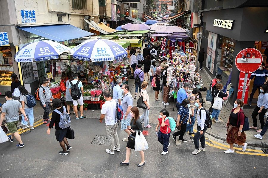 Pedestrians walk past market stalls along a street in Hong Kong on 24 November 2020. (Peter Parks/AFP)