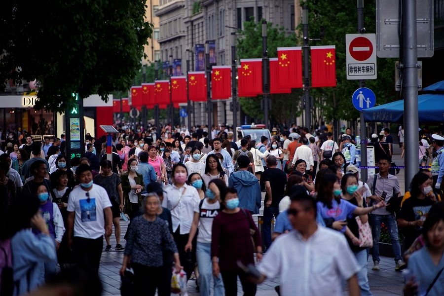 People walk along Nanjing Road, a main shopping area, in Shanghai, China, 10 May 2021. (Aly Song/Reuters)
