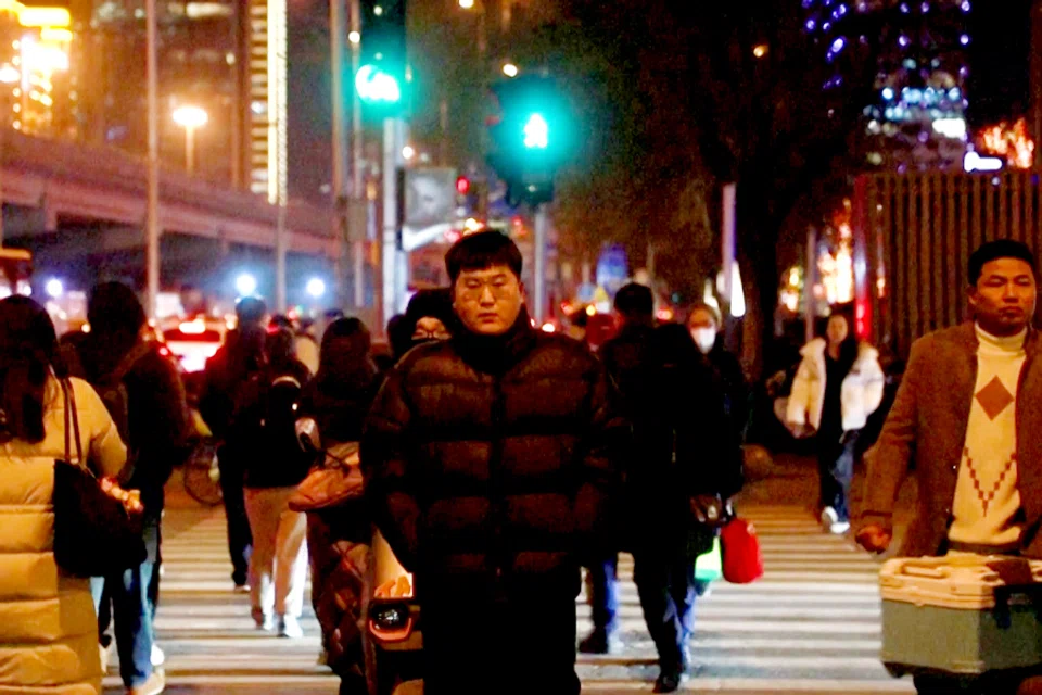 Youths walk on the street at night in Beijing, China, on 24 February 2024 (Screen grab from Reuters)