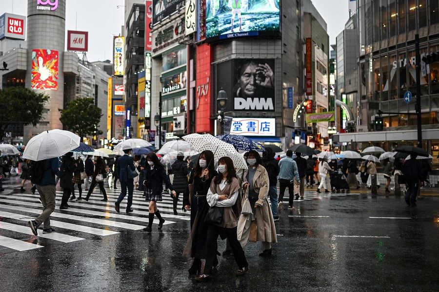 People use umbrellas to shelter from the rain while crossing a street in Tokyo on 19 October 2020. (Charly Triballeau/AFP)