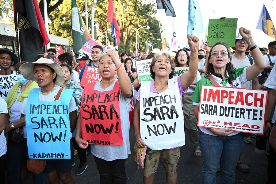 Protesters shout slogans as they carry placards during a rally in front of the House of Representatives in Manila on 5 February 2025, as members of congress voted to impeach Philippine Vice-President Sara Duterte. (Ted Aljibe/AFP)