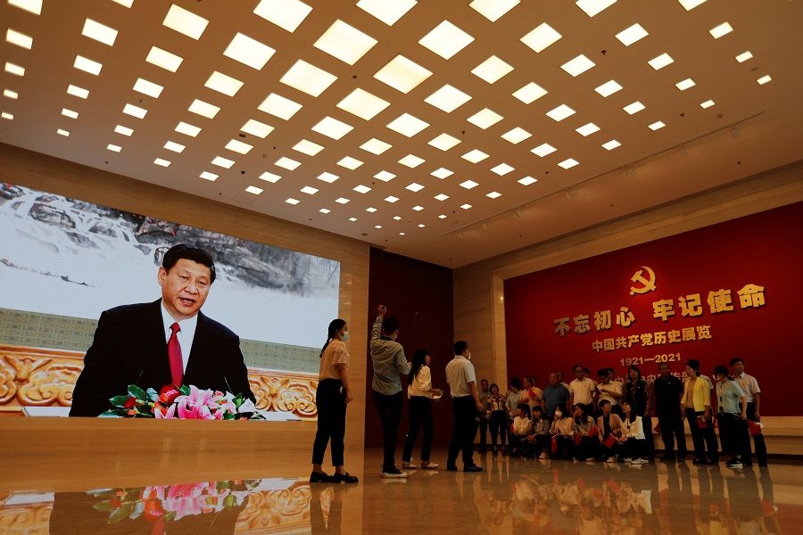 Visitors near a screen displaying an image of Chinese President Xi Jinping at the Museum of the Communist Party of China in Beijing, China, 3 September 2022. (Florence Lo/Reuters)