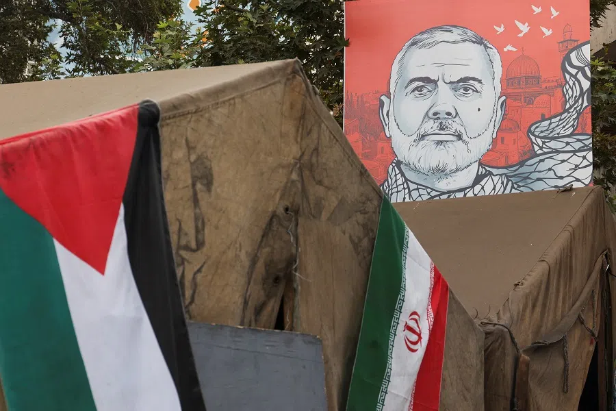 A banner with a picture of late Hamas leader Ismail Haniyeh is displayed next to the Iran and Palestinian flags in a street in Tehran, Iran, on 12 August 2024.