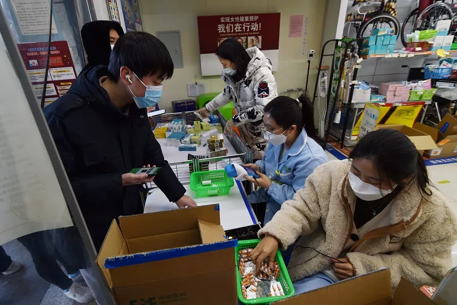 Customers buy medicine at a pharmacy in Nanjing, Jiangsu province, China, 19 December 2022. (China Daily via Reuters)