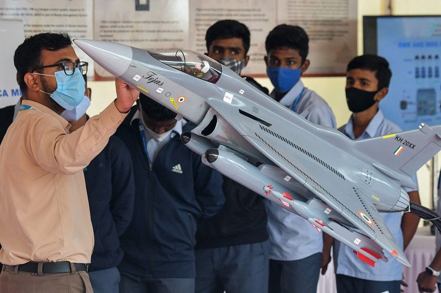 An employee of Bharat Electronics Limited (BEL) explains about the functioning of the radar that sits inside the nose of light combat aircraft 'Tejas' in Bangalore, India, on 13 December 2021. (Manjunath Kiran/AFP)