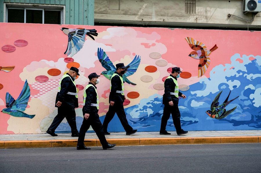 Security guards walk along a street in Beijing, China, on 9 May 2022. (Noel Celis/AFP)