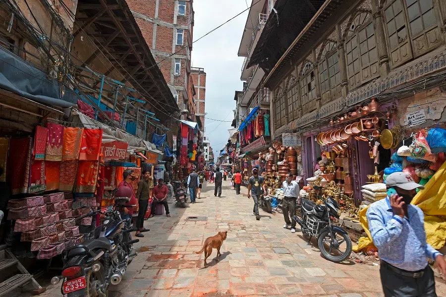 Pedestrians walk past a local market, which was reopened after an end to the Covid-19 coronavirus lockdown in Kathmandu on 22 July 2020. (Prakash Mathema/AFP)