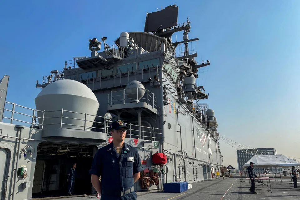 A sailor stands on the deck of the USS America (LHA-6) amphibious assault ship docked at a port in Manila, Philippines, 21 March 2023. (Adrian Portugal/Reuters)