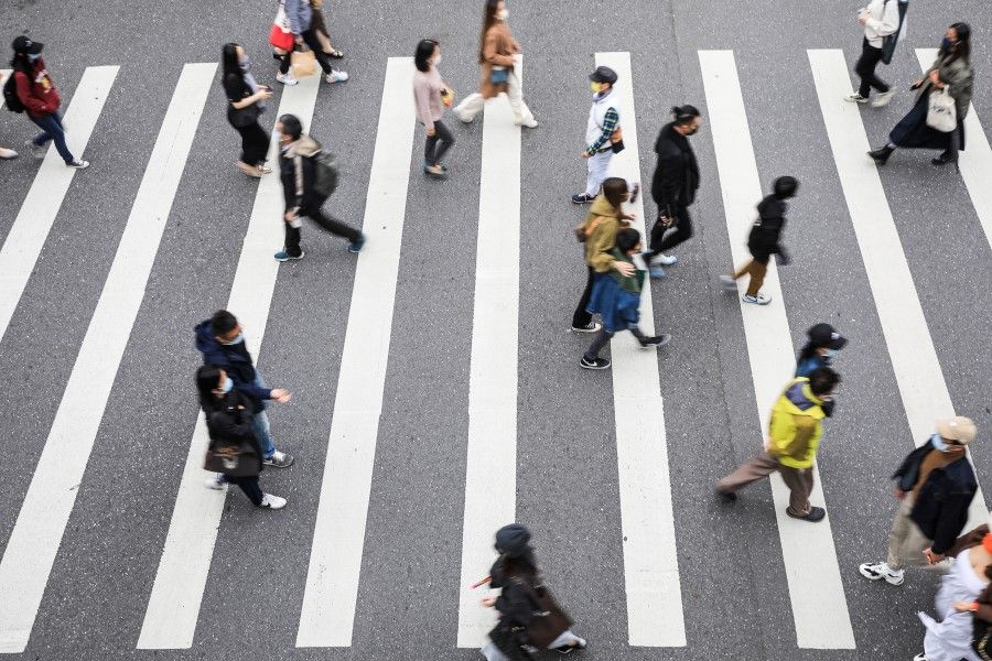 Pedestrians cross a road in the Xinyi district in Taipei, Taiwan, on 24 November 2021. Taiwan has been invited to the Summit for Democracy, to be hosted by the US. (I-Hwa Cheng/Bloomberg)