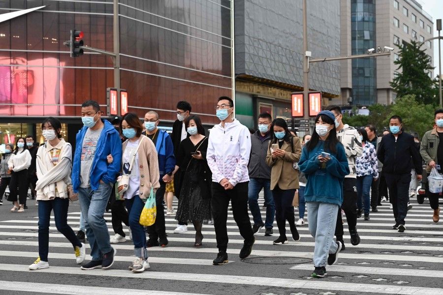 People walk on a pedestrian crossing in Beijing on 5 October 2021. (Jade Gao/AFP)