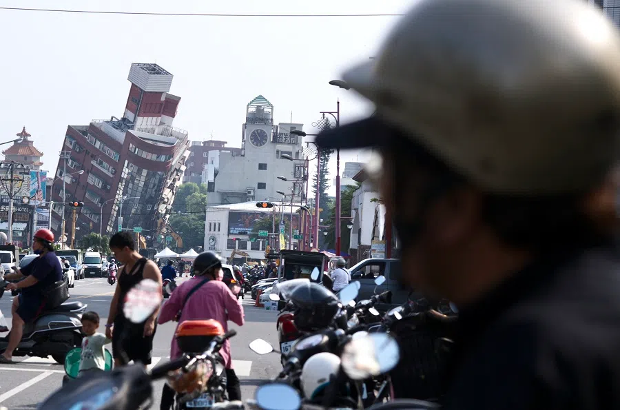 Residents ride past a building damaged by the earthquake in Hualien, Taiwan, on 4 April 2024.