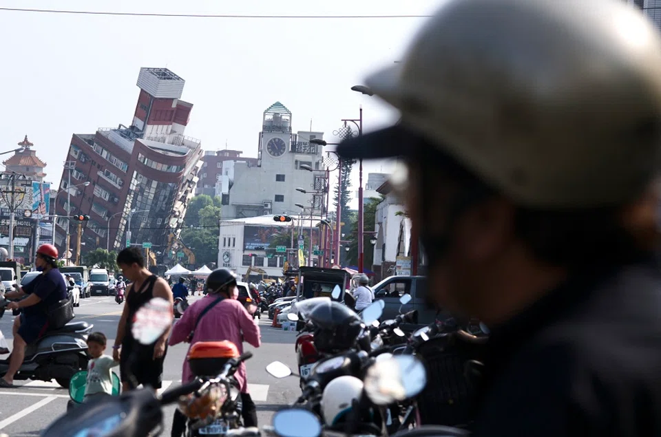 Residents ride past a building damaged by the earthquake in Hualien, Taiwan, on 4 April 2024. (Sam Yeh/AFP)