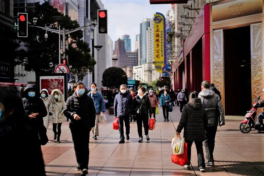 People wearing protective masks visit a main shopping area in Shanghai, China, 21 January 2022. (Aly Song/Reuters)