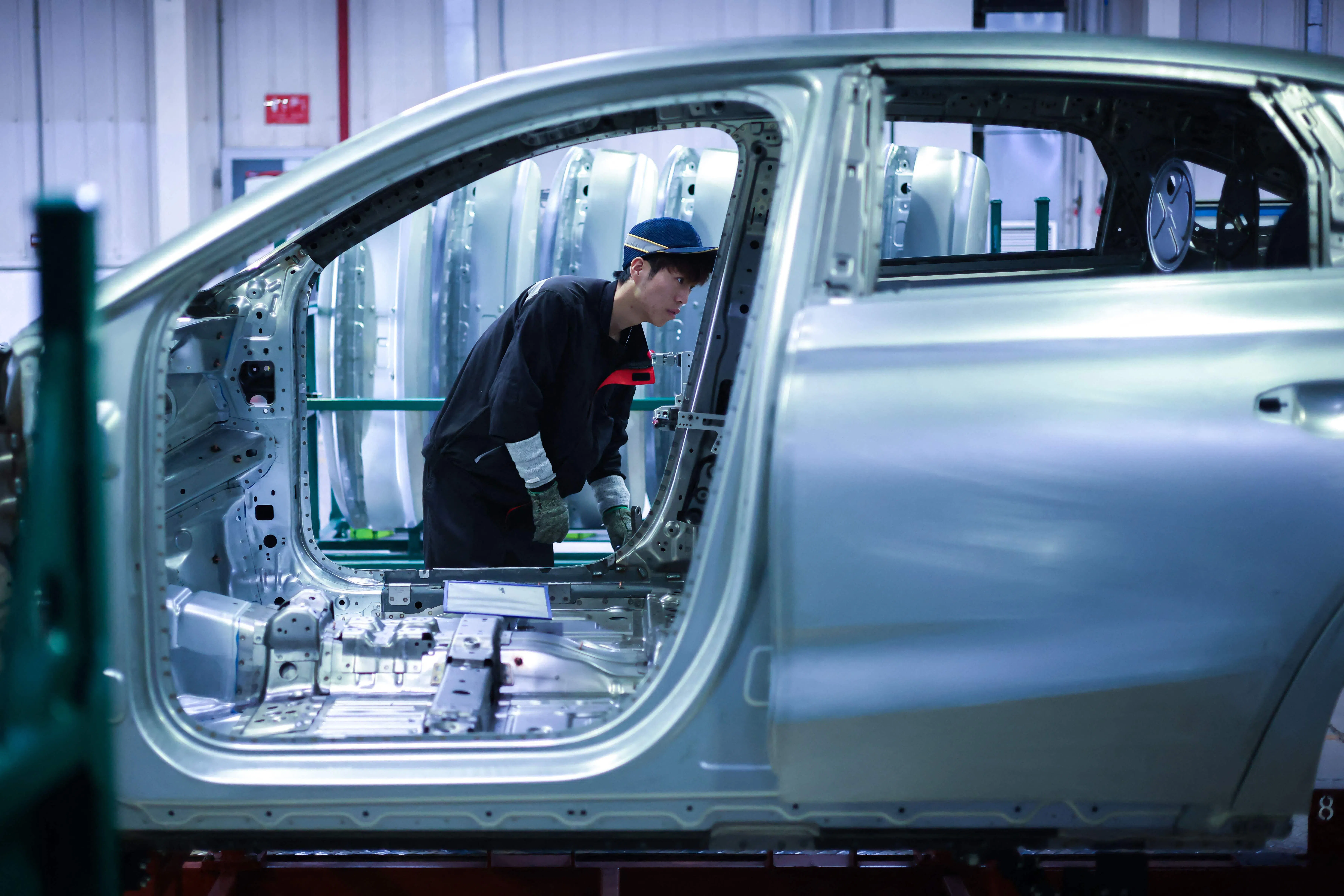 An employee works on a production line assembling methanol plug-in hybrid sedans at a Geely plant in Shenyang, Liaoning province, China, on 10 August 2026.