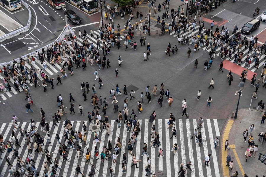 Crowds of people cross the street at Shibuya Crossing, one of the busiest intersections in the world, in the Shibuya district of Tokyo on 5 April 2023. (Richard A. Brooks/AFP)