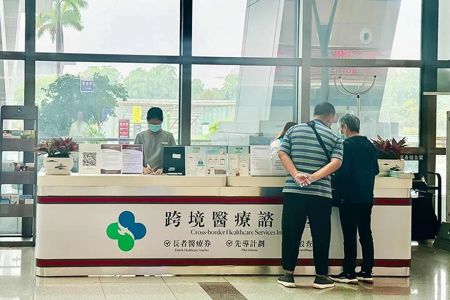 Two Hong Kong seniors ask about using elderly healthcare vouchers at the cross-border medical information desk at the University of Hong Kong-Shenzhen Hospital.