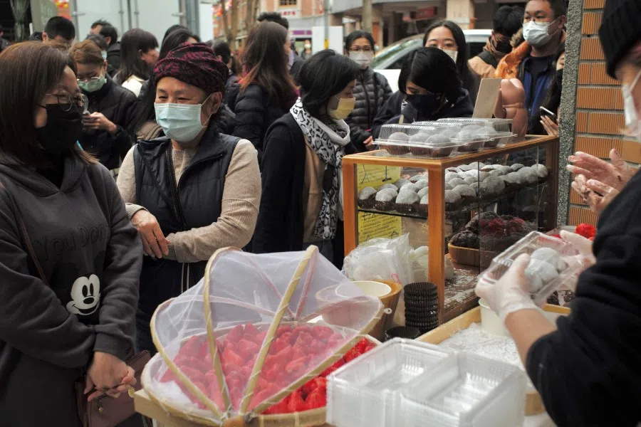 Local residents queue up to buy desserts at the traditional market on Dihua Street in Taipei on 20 January 2022. (Sam Yeh/AFP)