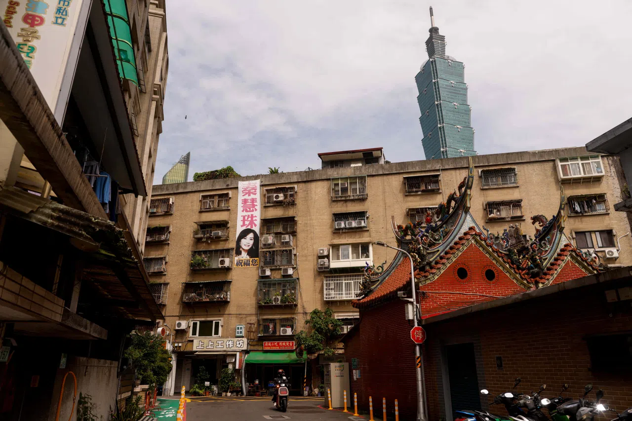 Taipei 101 rises in the background above residential buildings and a temple roof in Taipei, Taiwan, 12 May 2026.